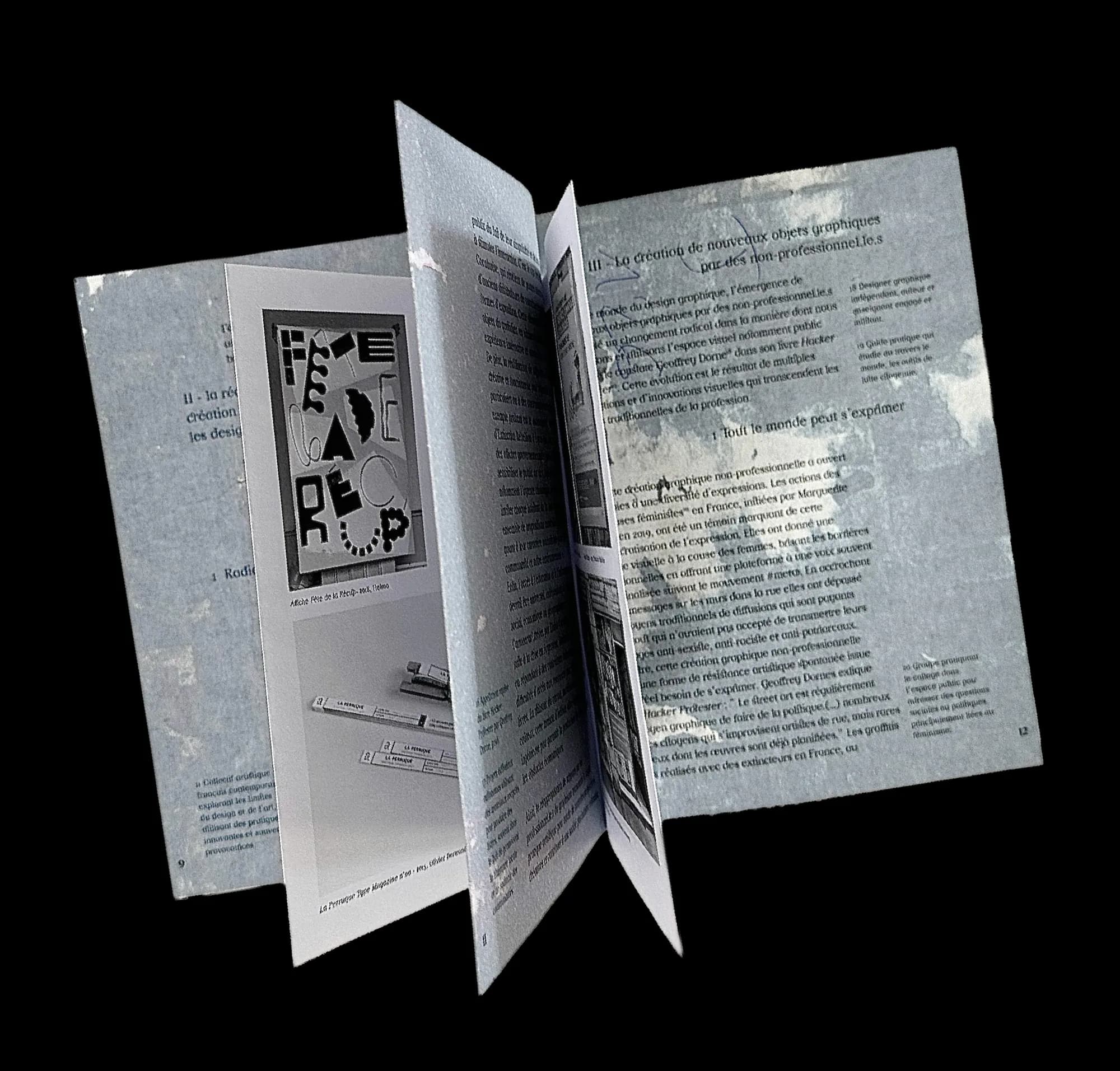 Le mémoire ouvert en éventail sur fond noir : pages à fond bleu texturé, texte et images en noir